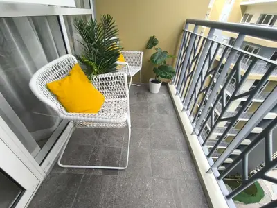 a balcony with two chairs and a yellow pillow at Comfortable and Relaxing 1BR Unit in Manila