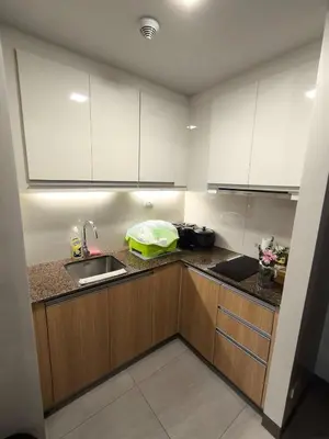 a kitchen with white cabinets and a sink at Comfortable and Relaxing 1BR Unit in Manila