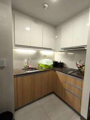 a kitchen with wooden cabinets and a sink at Comfortable and Relaxing 1BR Unit in Manila