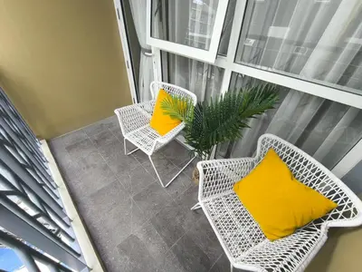an apartment balcony with two chairs and a yellow pillow at Comfortable and Relaxing 1BR Unit in Manila