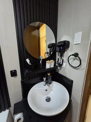 a bathroom with a sink and a mirror at Skye Staycation 2 in Manila