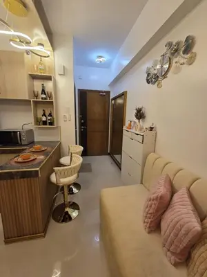 a living room with a couch and a kitchen at Skye Staycation 2 in Manila