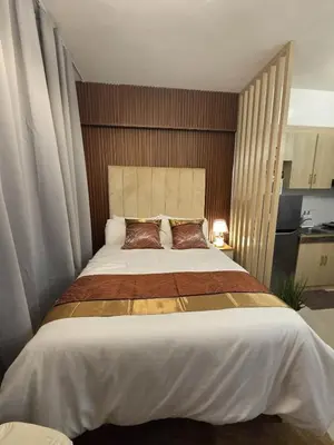 a bedroom with a large bed with brown pillows at Skye Staycation 2 in Manila