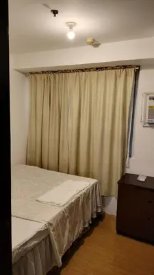 a bedroom with a bed and a window with curtains at 2BR Condo FF, Great View, Taguig ,UNDER RENOVATION in Manila