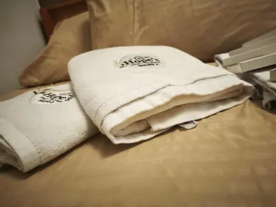 a pile of towels sitting on top of a bed at MOA Staycation in Manila