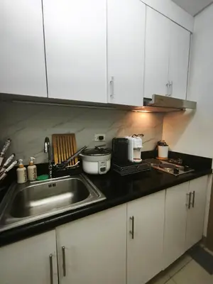 a kitchen with a sink and a counter top at MOA Staycation in Manila