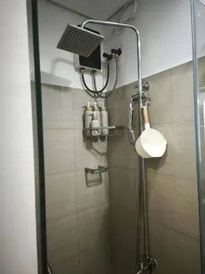 a shower with a shower head in a bathroom at MOA Staycation in Manila
