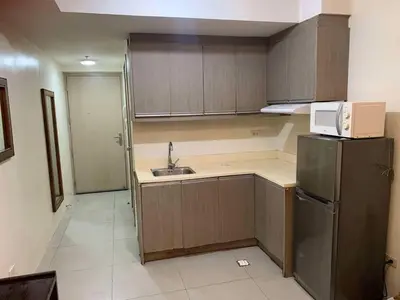 a small kitchen with a sink and a refrigerator at Condo in Poblacion, Makati in Manila