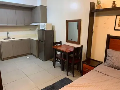 a kitchen with a table and a sink and a room at Condo in Poblacion, Makati in Manila