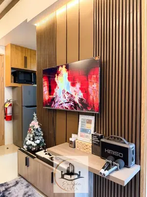 a living room with a tv on a wall at Eutopia Vista- 2 Bedroom Condo in SMDC Bloom in Manila