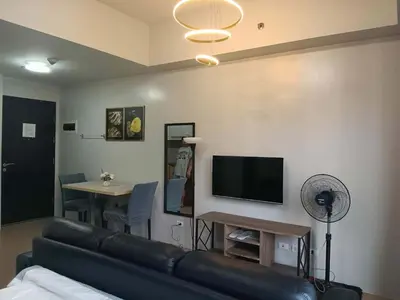 a living room with a couch and a tv and a table at Cluster 1 9N in Manila