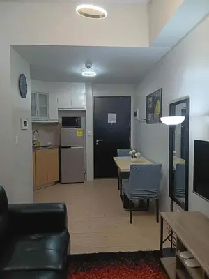 a kitchen and a living room with a table and chairs at Cluster 1 9N in Manila
