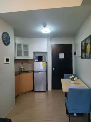 a kitchen with a refrigerator and a table with chairs at Cluster 1 9N in Manila