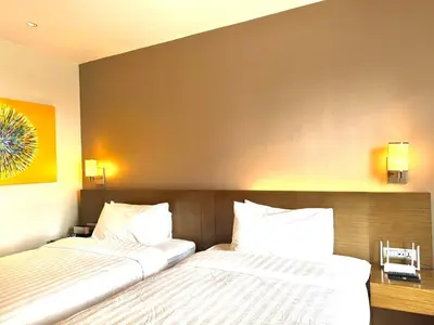 two beds sitting next to each other in a bedroom at Mesmerizing Twin Bed with Rockwell View in Manila