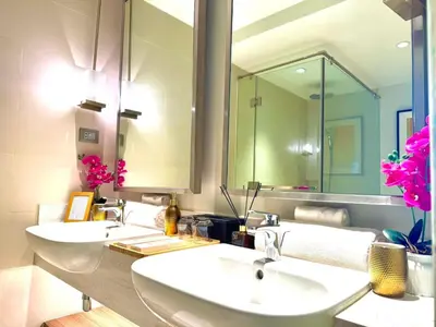 a bathroom with two sinks and a large mirror at Mesmerizing Twin Bed with Rockwell View in Manila