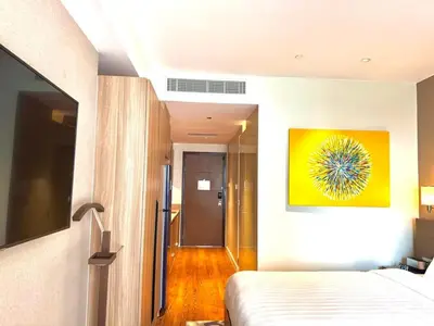 a bedroom with a bed and a yellow painting on the wall at Mesmerizing Twin Bed with Rockwell View in Manila