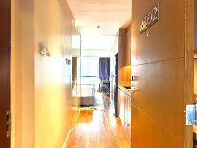 a hallway with a room with a bed in the distance at Mesmerizing Twin Bed with Rockwell View in Manila