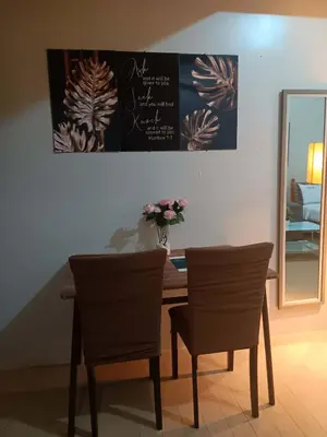 a dining room table with two chairs and a mirror at Cluster 4 7G in Manila