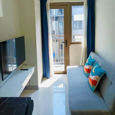 a living room with a blue couch and a television at S Residences by Seren View-main in Manila
