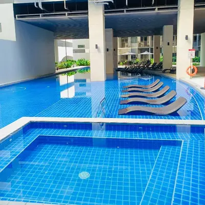 a swimming pool with lounge chairs in a building at S Residences by Seren View-main in Manila