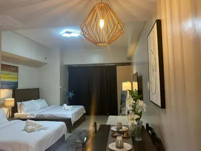 a hotel room with two beds and a table and a chandelier at Cluster 4 5D in Manila