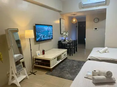 a room with two beds and a television on the wall at Cluster 4 5D in Manila