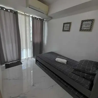 a bedroom with a bed and a large window at azure urban resort residences in Manila