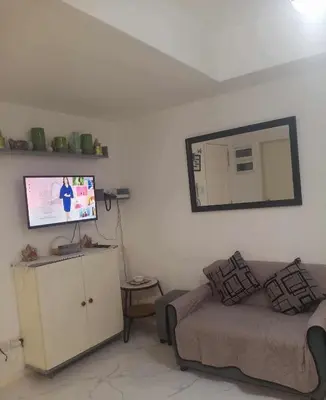 a living room with a couch and a mirror at azure urban resort residences in Manila