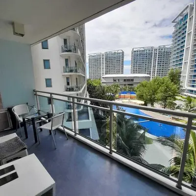 a balcony with a view of a pool and buildings at azure urban resort residences in Manila