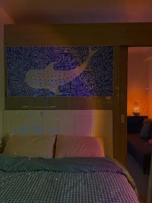 a bedroom with a bed with a painting above it at Whimsy Stay in Manila