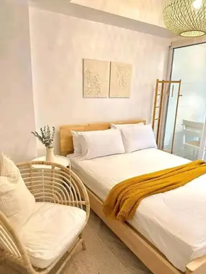 a bedroom with a bed and a chair and a window at Vacation Home by Star in Manila