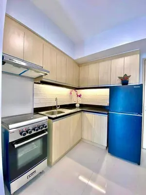a kitchen with a stove and a blue refrigerator at Vacation Home by Star in Manila
