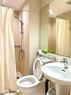 a white bathroom with a toilet and a sink at Vacation Home by Star in Manila