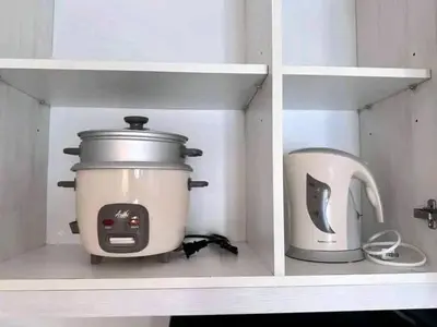 a slow cooker and a toaster sitting on a shelf at Vacation Home by Star in Manila