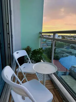 a balcony with two chairs and a table and a window at Vacation Home by Star in Manila