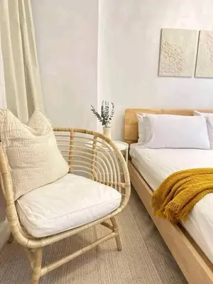 a bedroom with a wicker chair and a bed at Vacation Home by Star in Manila