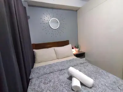 a bedroom with a bed with a mirror on the wall at Shore Residences at Mall Of Asia Complex - by Staycation Empire in Manila