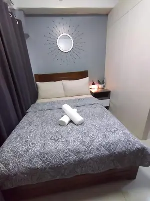 a bedroom with a bed with two towels on it at Shore Residences at Mall Of Asia Complex - by Staycation Empire in Manila