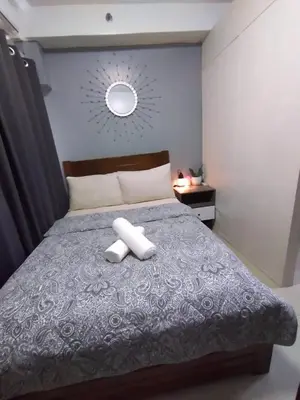 a bedroom with a bed with two towels on it at Shore Residences at Mall Of Asia Complex - by Staycation Empire in Manila