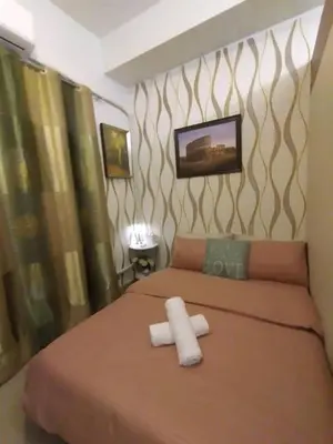 a bedroom with a large bed with two towels on it at Shore Residences at Mall Of Asia Complex - by Staycation Empire in Manila