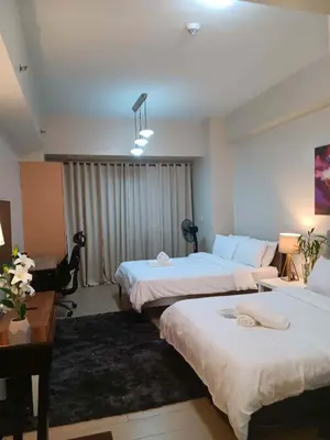 a hotel room with two beds and a desk at Cluster 5 9H in Manila