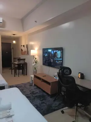 a hotel room with a bed and a tv on the wall at Cluster 5 9H in Manila