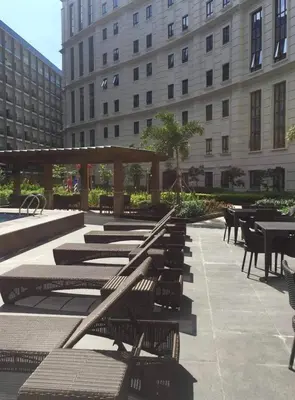 a row of benches and tables in a courtyard with a building at A Home Away From Home in Manila