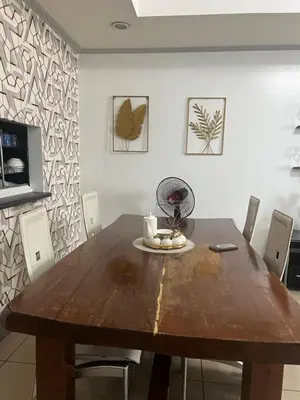 a wooden table in a dining room with chairs at Birch tower Condominium in Manila