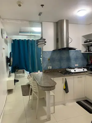 a kitchen with a table and chairs in a room at Birch tower Condominium in Manila