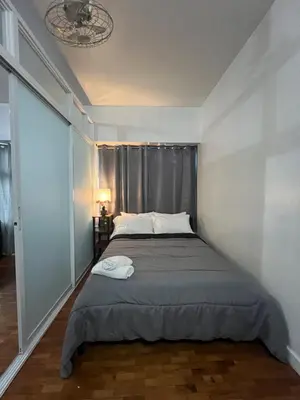 a bed in a room with a large window at Robinson's Place Residences, in Manila