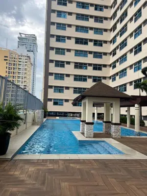 a swimming pool with a gazebo in front of a building at Robinson's Place Residences, in Manila