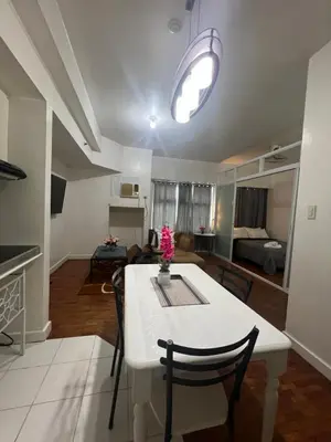 a kitchen and living room with a white table and chairs at Robinson's Place Residences, in Manila