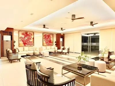 a large living room with chairs and tables at Trouvaille in Red Residences in Manila