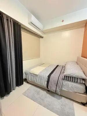 a bedroom with two beds and a window at Trouvaille in Red Residences in Manila